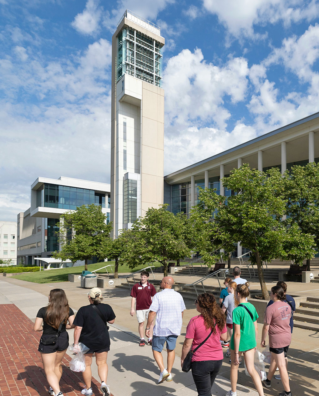 Tour guide leading a group of students on a walking tour past the Jane A. Meyer Carillon at Missouri State University